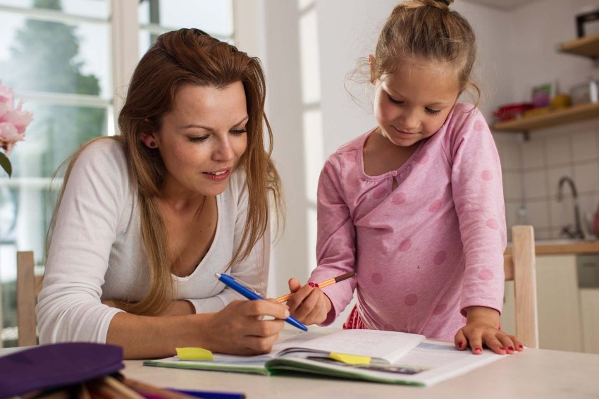 Mutter mit Tochter bei den Hausaufgaben